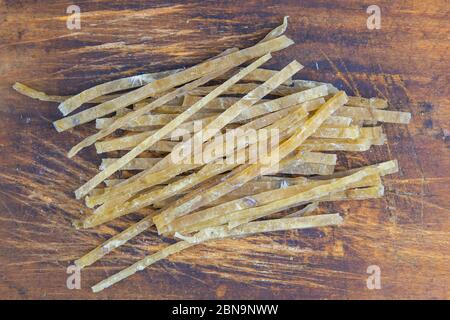 Dried salted tuna elite snack on wooden background. Snack Fish to beer. Close up Stock Photo