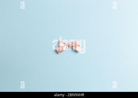 Dot pattern pink bow ribbon isolated on sky blue background Stock Photo