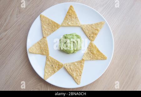 Beautiful shot of potato chips on a plate with homemade salsa Verde sauce Stock Photo