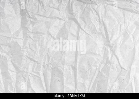 White wrinkled creased paper texture. Blank crumpled grainy paper textured surface. Smudged grungy grey poster. Close up. Material tissue for packing. Stock Photo