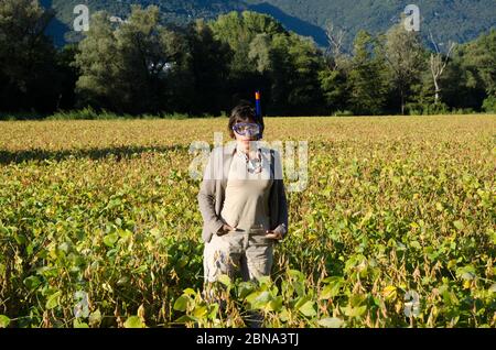 Businesswoman in a suit standing in the field with a diving mask Stock Photo