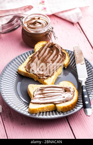 Toast bread with hazelnut spread. Sweet chocolate cream on plate. Stock Photo