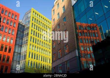Colourful building of Central Saint Giles, reflected in the windows of an office block. Central Saint Giles was designed by the Italian architect Renz Stock Photo