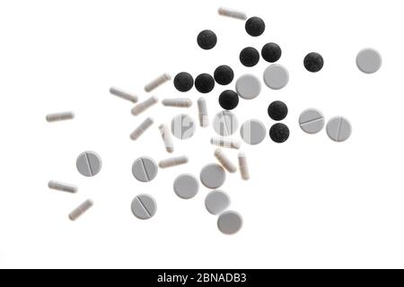 Various white and black tablets, capsules, pills and dragees on a white background, Germany, Europe Stock Photo