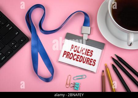 POLICIES and PROCEDURES concept. Staff Identity, cup of coffee and black computer keyboard on a pink background Stock Photo