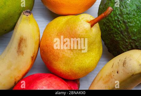 Overhead closeup shot of pear and several other fruits surrounding it Stock Photo
