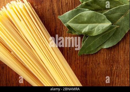 raw spaghetti on the table with spices. Long pasta Stock Photo