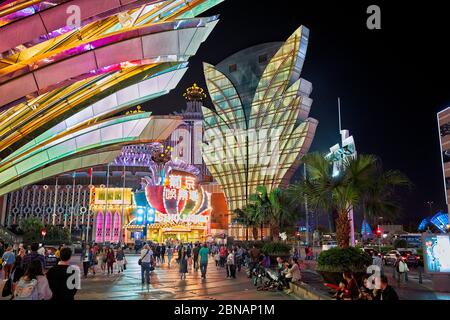 People walking at the Grand Lisboa Hotel and Casino brightly illuminated at night. Macau, China. Stock Photo