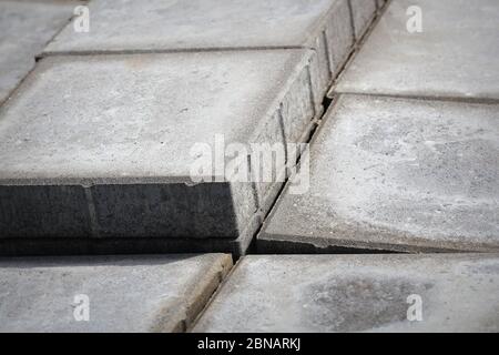 Stack of gray paving slabs. Construction of sidewalks. Building materials for the construction of the sidewalk. Stock Photo