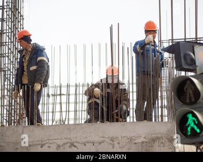 Construction workers collaborating in the installation  fittings at a construction site. Stock Photo