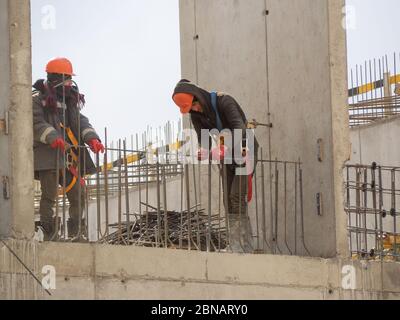 Construction workers collaborating in the installation  fittings at a construction site. Stock Photo
