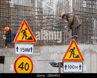 Construction workers collaborating in the installation  fittings at a construction site. Stock Photo