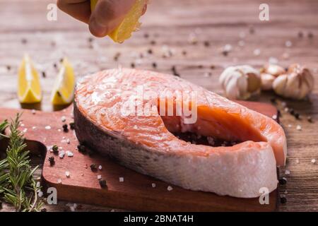 Fish Menu. Cook man plating salmon steak squeezing lemon juice. Selective Focus Stock Photo