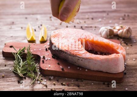 Fish Menu. Cook man plating salmon steak squeezing lemon juice. Selective Focus Stock Photo