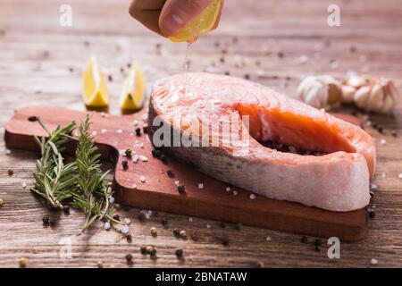 Fish Menu. Cook man plating salmon steak squeezing lemon juice. Selective Focus Stock Photo