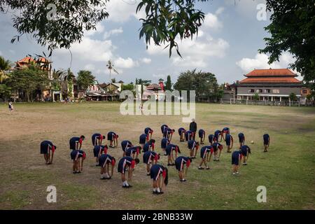 Horizontal view of sportive school training in a city center park, Ubud, Bali, Indonesia Stock Photo