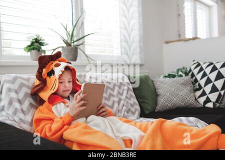 beautiful young Girl with lion costume plays with mobile phone or tablet Stock Photo