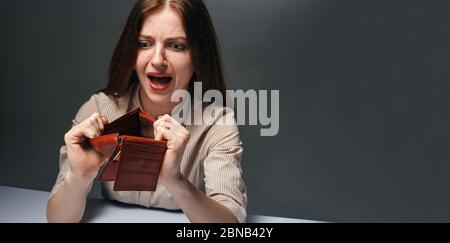 Young woman shows her empty wallet. Bankruptcy concept Stock Photo