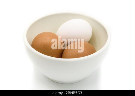 Brown and white eggs in a bowl isolated on white background Stock Photo