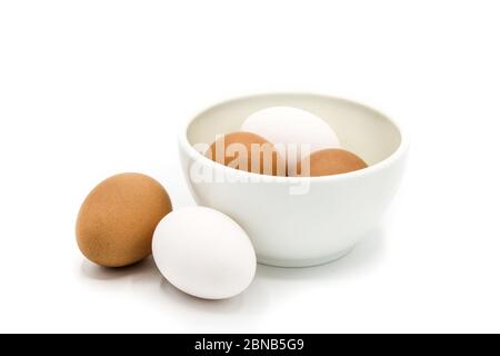 Brown and white eggs in a bowl isolated on white background Stock Photo