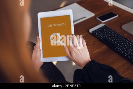 Woman looking for a job during worldwide crisis. Find a job online. Business, internet and networking concept. Woman looks through vacancies and sends resumes, needs to earn. Modern digital search bar. Stock Photo