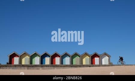 A clear blue sky over beach huts in Blyth, Northumberland, as highs of 22C are now expected for some parts of the UK by the weekend. Stock Photo