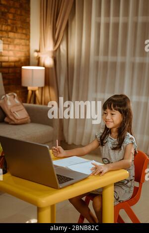 happy asian child studying at home in the evening Stock Photo