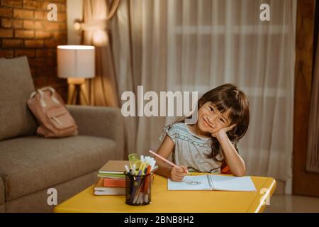 happy asian child studying at home in the evening Stock Photo