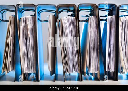 Office folders with archived paperwork in a row in blue light Stock Photo