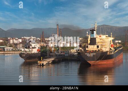Santiago, Cuba, two small oil tankers docked at an oil refinery