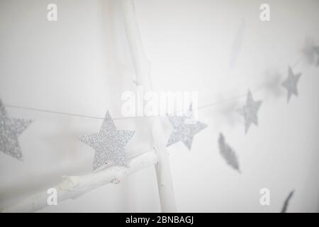 Paper stars are shiny silver on a white background. Stock Photo