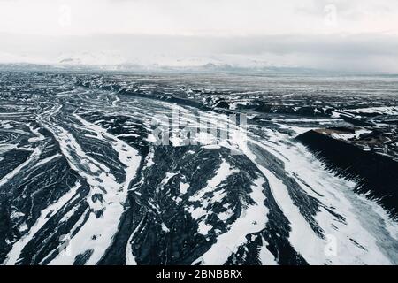 Aerial view of the volcanic desert on Iceland, in the background a glacier, black rock, filming location Interstellar Stock Photo