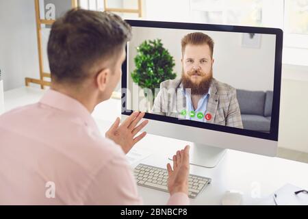 Online work training education video chat call webcam conference. Male coach says business course video conferencing online webcam chat using computer Stock Photo
