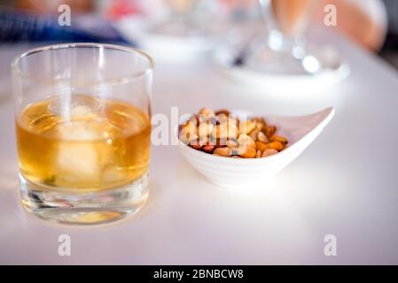 whiskey and nuts on white table Stock Photo