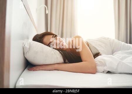 Pretty woman daydreaming in her bed in the morning Stock Photo