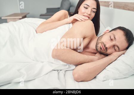 Woman waking up her husband in the morning Stock Photo
