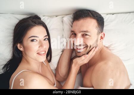 Married couple lying on the pillows in bed Stock Photo