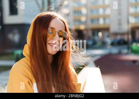 Close up portrait of happy smiling red hair woman in sunglasses