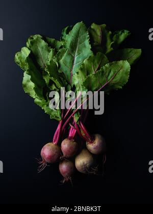 Bunch of fresh beetroots on black background, top view Stock Photo