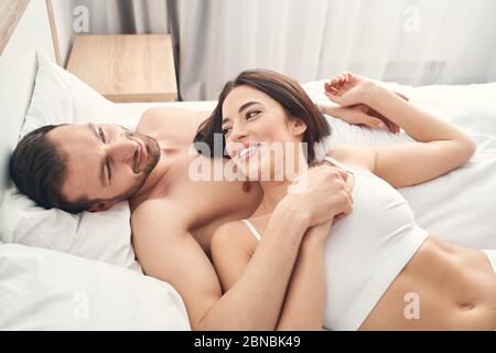 Joyful lady lying on her husbands chest Stock Photo