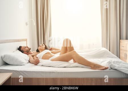 Newly married couple daydreaming together in bed Stock Photo