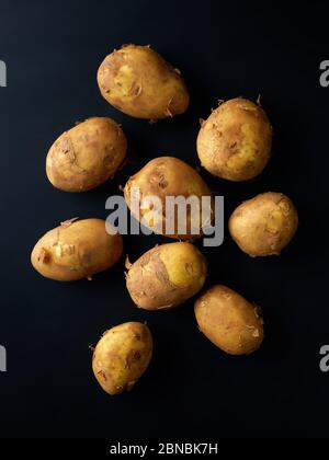 Heap of new potatoes on black background, top view Stock Photo