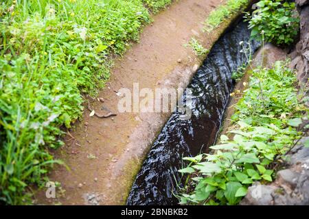 Closeup of the small irrigation channel at the farmland Stock Photo