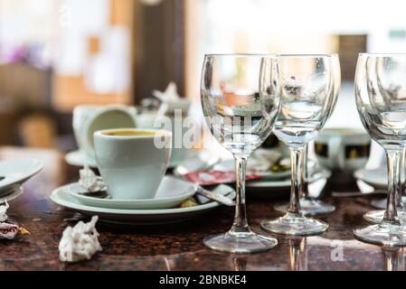 dirty and used glass plates, cups and glasses on a restaurant table Stock Photo