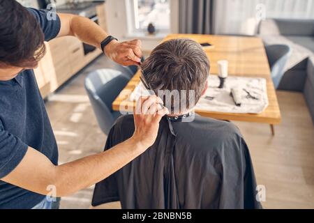 Man sitting in front of the table and getting new haircut Stock Photo