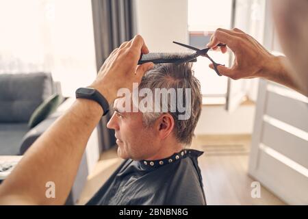 Photo of man getting new trendy hairstyle Stock Photo