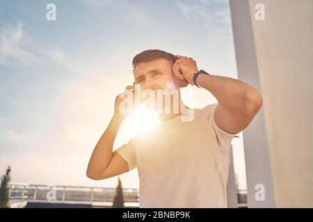 Caucasian male in headphones enjoying warm weather Stock Photo