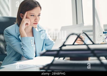 Attractive young lady working in modern office Stock Photo