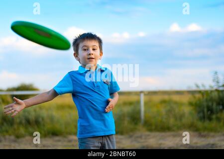 Boy playing with frisbee outdoors on sunset. Summer holidays concept Stock Photo