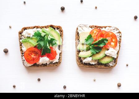 Avocado toast with cherry tomatoes and feta cheese on plate. Stock Photo